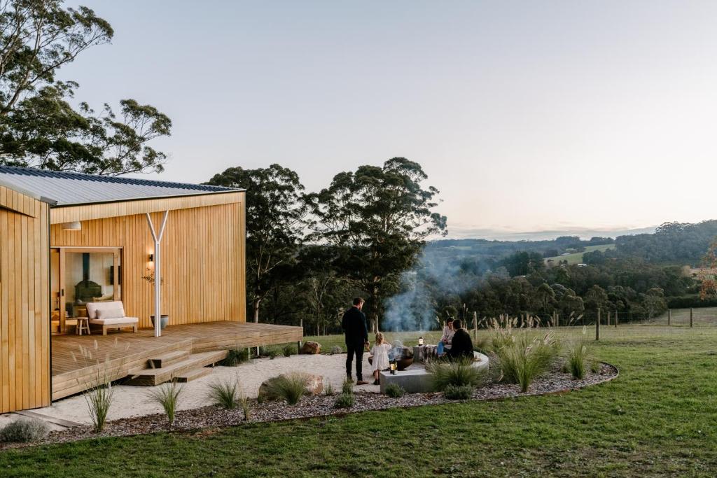 丹马克Upland Farm Luxury Cabins, Denmark Western Australia的站在小房子外的家庭