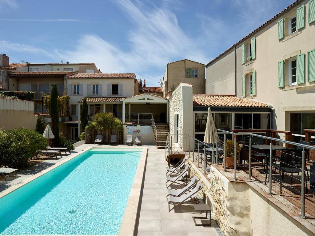 圣马丹德雷Villa de L'Eclusier的一座带椅子的游泳池,位于大楼旁