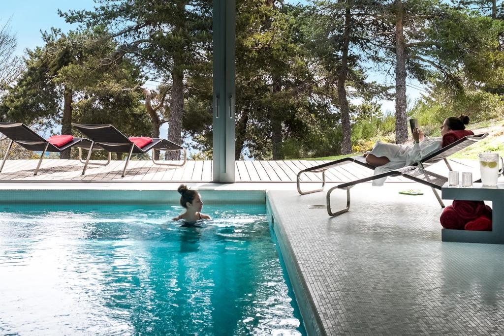 曼泰加什Casa das Penhas Douradas - Burel Mountain Hotels的妇女在游泳池游泳