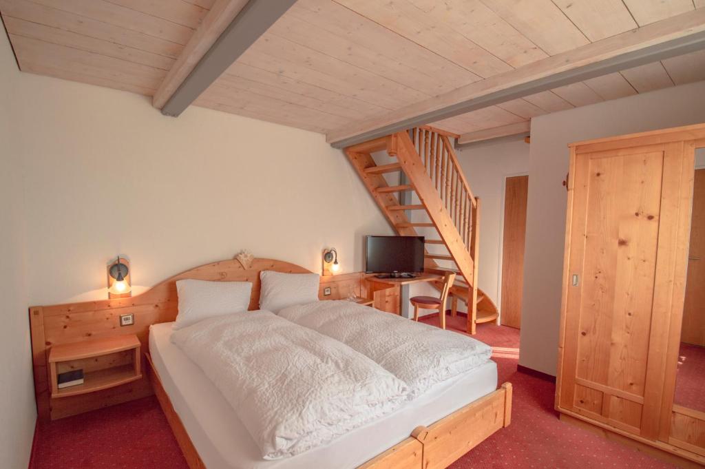 菲施艾格西翁酒店的一间卧室设有一张床和木制楼梯。