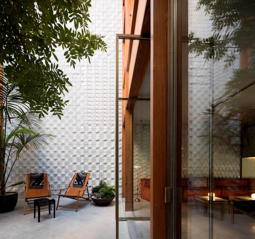 波尔图Hotel Tipografia do Conto by Casa do Conto的玻璃门通向带椅子的庭院
