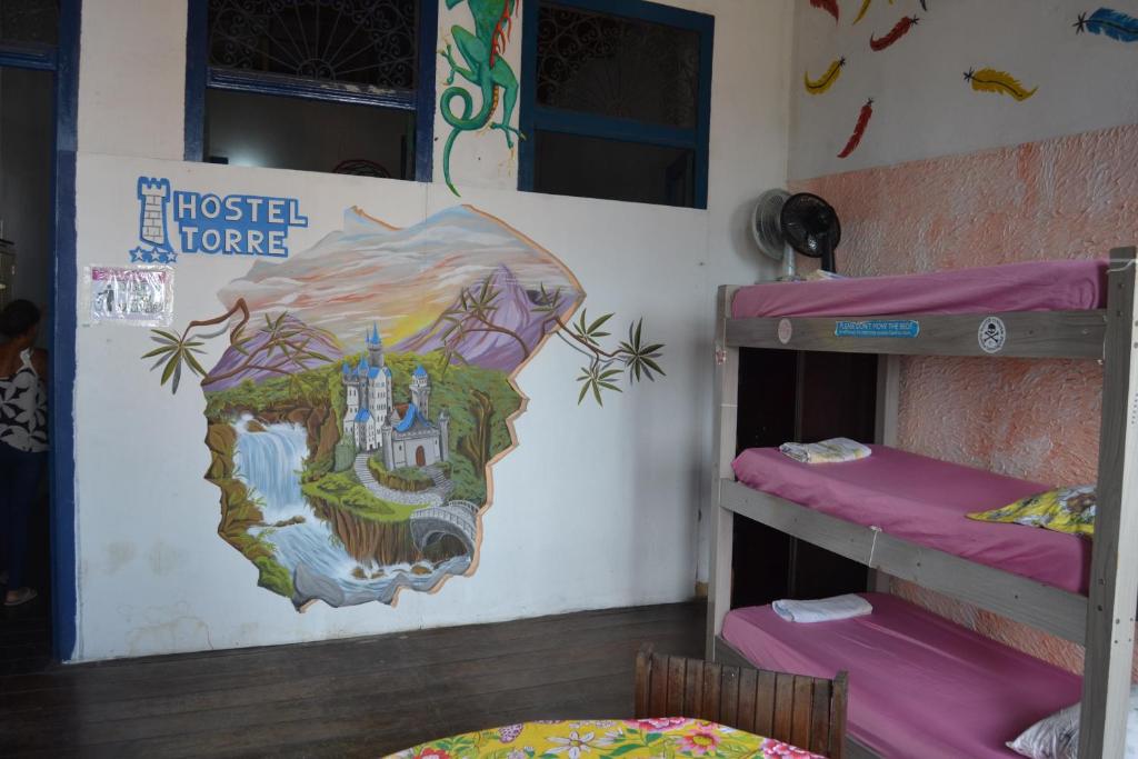 萨尔瓦多Hostel Torre Bahia-Familia的客房设有两张双层床,墙上挂有绘画作品