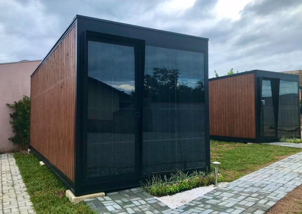 佩尼亚Modo- lar mini casa的一座黑色的建筑,在院子里设有玻璃门