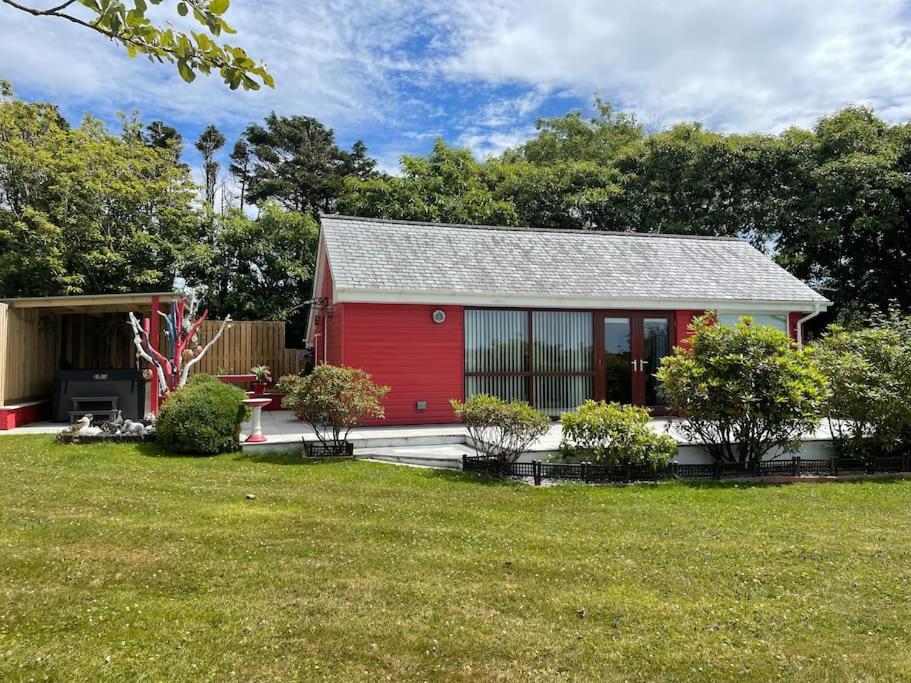 特鲁罗Meadowside Lodge with Hot Tub的院子里有红色门的红色房子