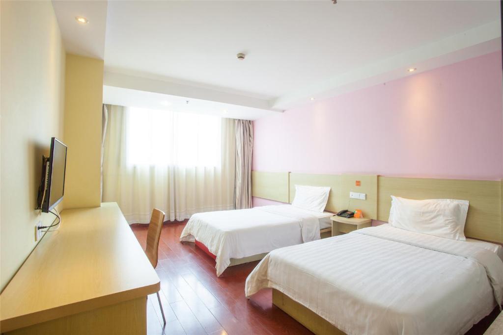 大连7天连锁酒店大连甘井子区政府的酒店客房设有两张床和一台平面电视。