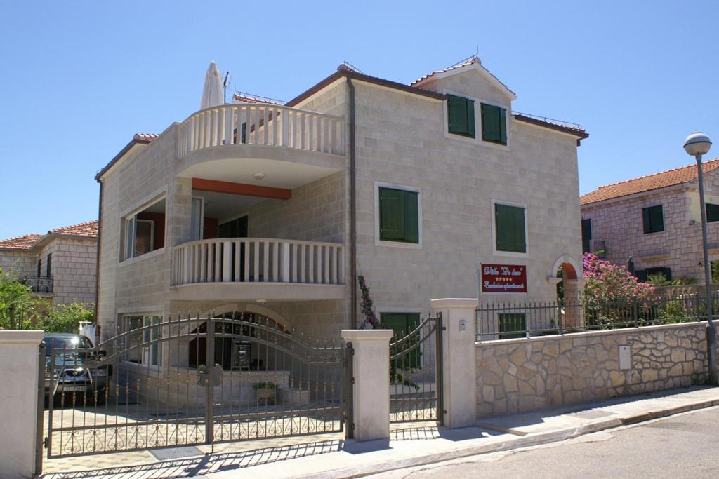 苏佩塔尔Apartments by the sea Supetar, Brac - 4274的前面有栅栏的建筑