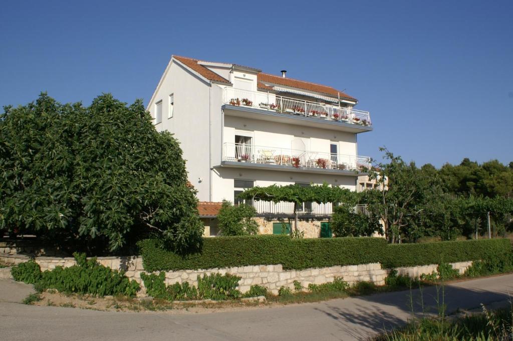 布罗达里卡Apartments with a parking space Brodarica, Sibenik - 4239的一座白色的建筑,人们坐在阳台上