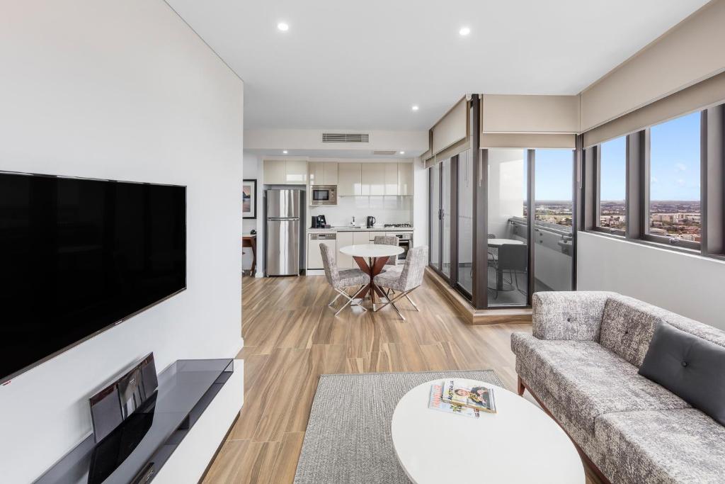 悉尼帕拉马塔教堂街美利通公寓式酒店的带沙发和平面电视的客厅