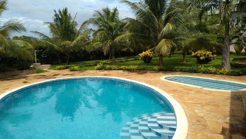 迪亚尼海滩Galu Gardens Apartments Diani Beach的棕榈树庭院内的游泳池