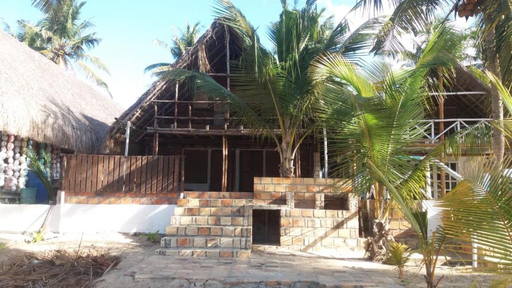 伊尼扬巴内Casa Coco Palmeira的前面有棕榈树的房子