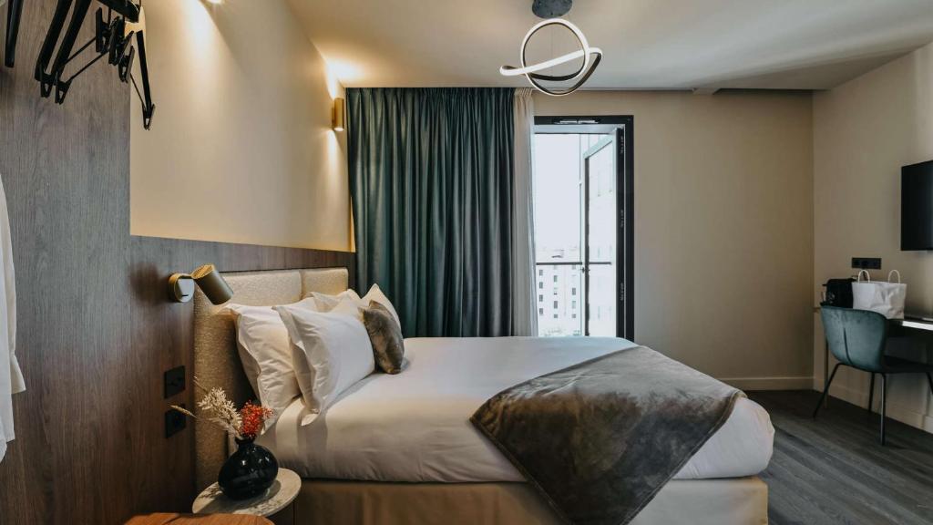 里昂Keystone Boutique Hôtel的酒店客房设有一张床和一个大窗户