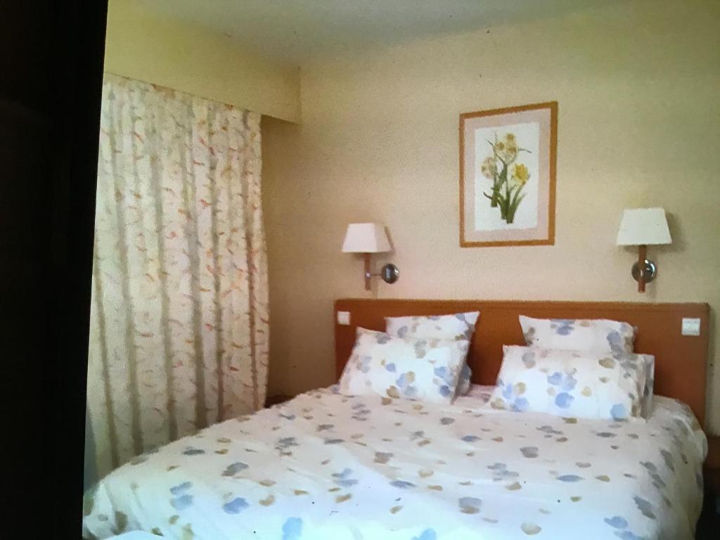 2p sur le golf de La Baule的一间卧室配有一张带蓝色和白色枕头的床