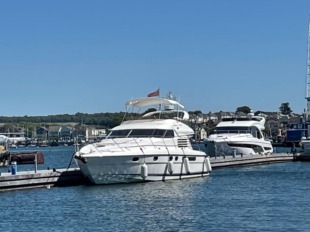 普里茅斯Tranquility Yachts -a 52ft Motor Yacht with waterfront views over Plymouth.的两艘船停靠在水面上的码头