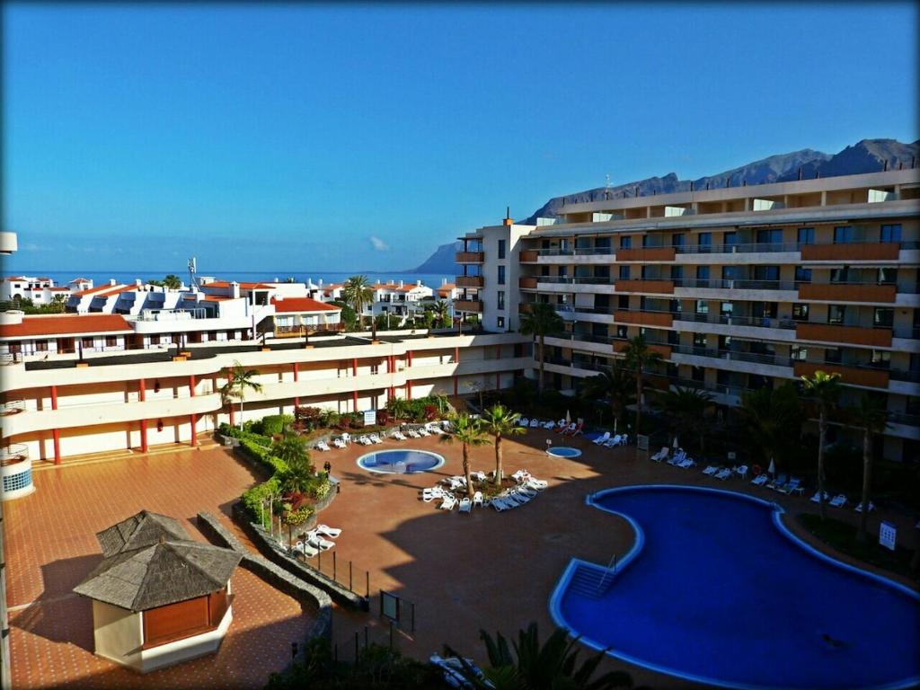 圣地亚哥港Apartamento Balcon de Los Gigantes的享有带游泳池的度假村的空中景致