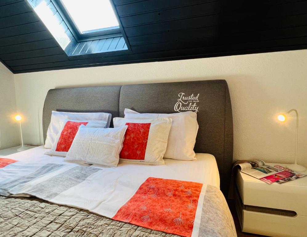 赫维兹Heviz Apart Comfort的一间卧室配有一张带红色和白色枕头的大床