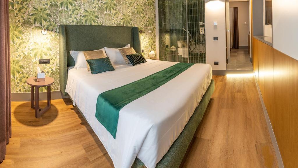 罗马Castel Sant´Angelo Luxury Rooms & Tour的卧室内的一张带绿色床头板的大床