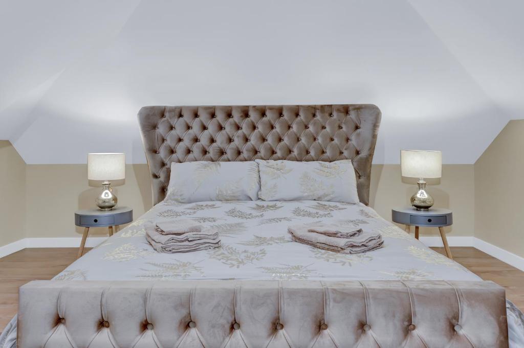 达特福德Suites by Rehoboth - Makeba Suite - Dartford的一间卧室配有一张大床和两盏灯