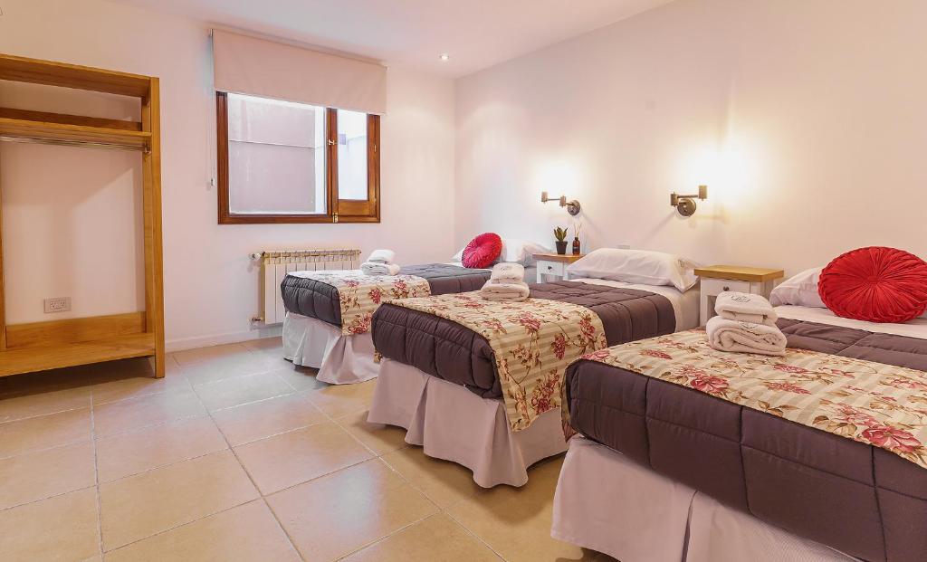 乌斯怀亚Isla Bonita Suites的酒店客房设有三张床和窗户。