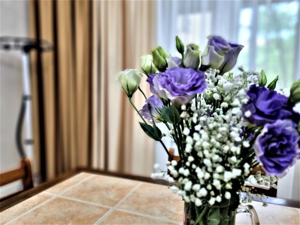 阿拉木图Очень уютная квартира рядом с посольством США的花瓶,上面布满了紫色的花朵