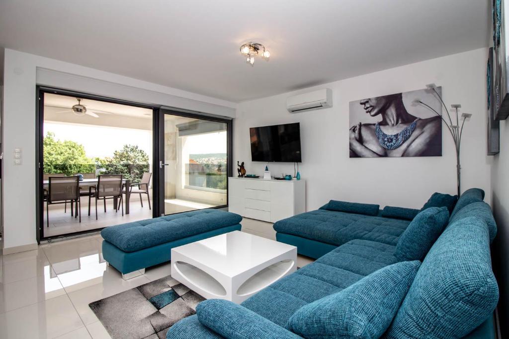 万塔西西Luxury Apartment Luna的客厅配有2张蓝色的沙发和1张桌子