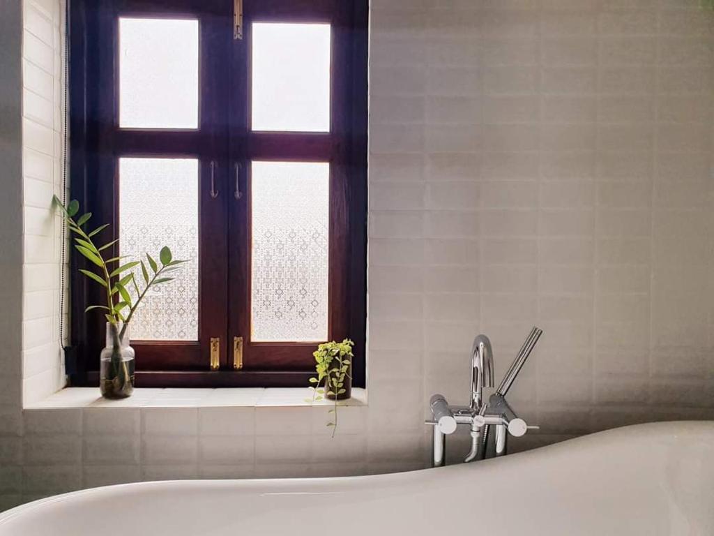 北碧Sittisang1920的带浴缸的浴室和窗户。