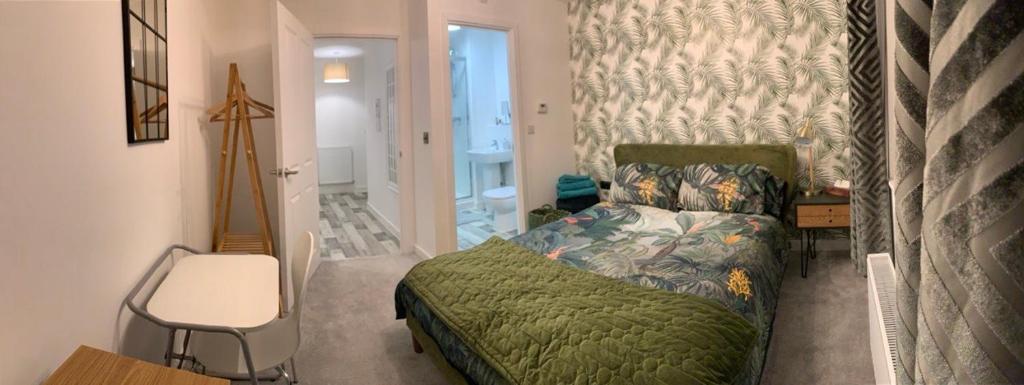 彼得伯勒Peterborough City Center One Bed apartment With Free Private Parking的卧室配有1张床、1张桌子和1把椅子