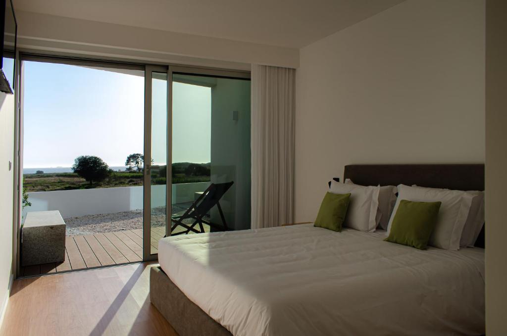 埃斯波森迪Marinhas Bed & Breakfast的一间带一张白色大床的卧室和一个阳台
