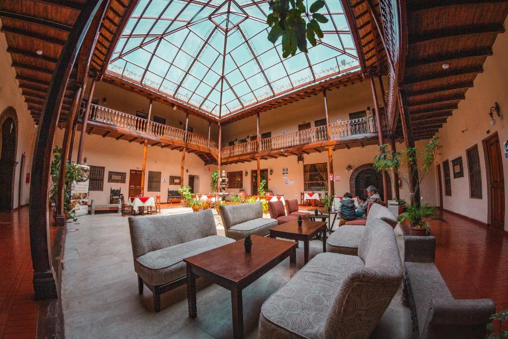 卡哈马卡Hotel Cajamarca的大型客房设有沙发、桌子和玻璃天花板。