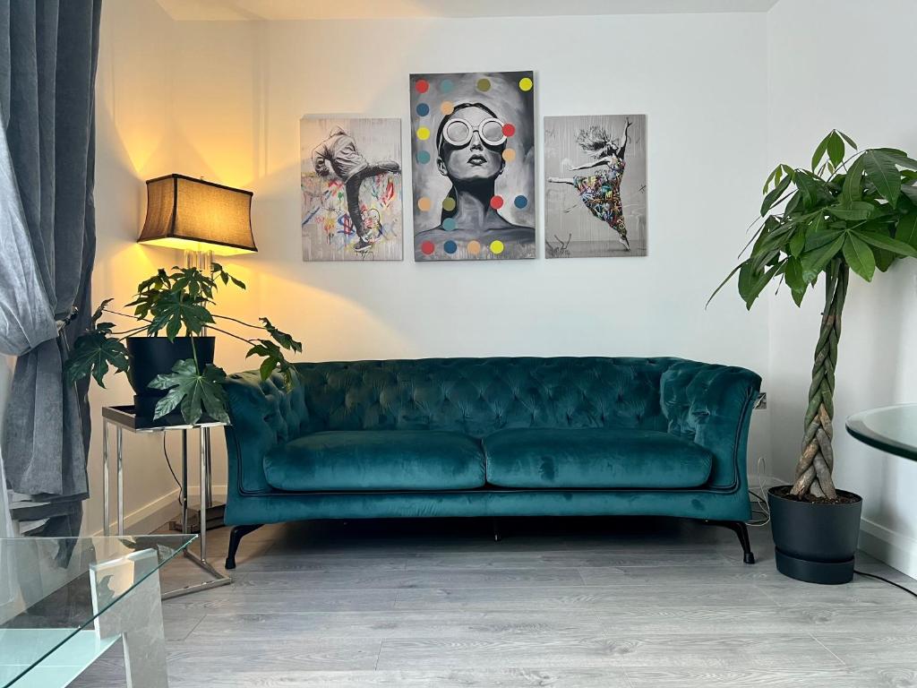 卡斯尔巴Lovely Apartment in Castlebar的客厅里一张绿色沙发,上面有四幅画