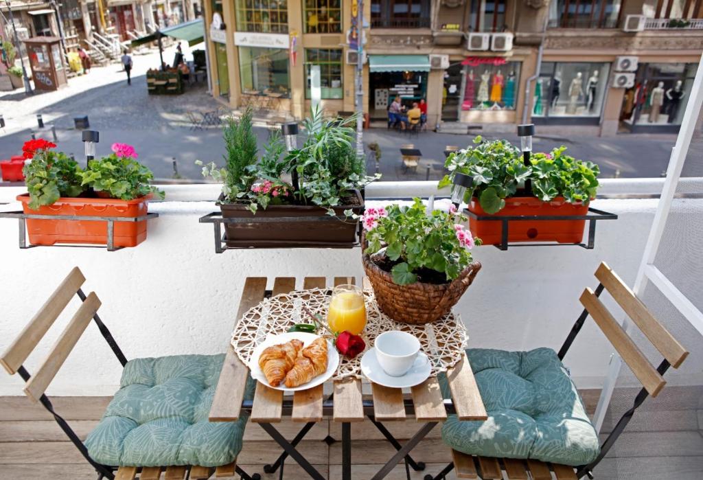 布加勒斯特Traditional Romanian Apartments Old Town City的一张桌子,上面放着一盘羊角面包和一杯橙汁