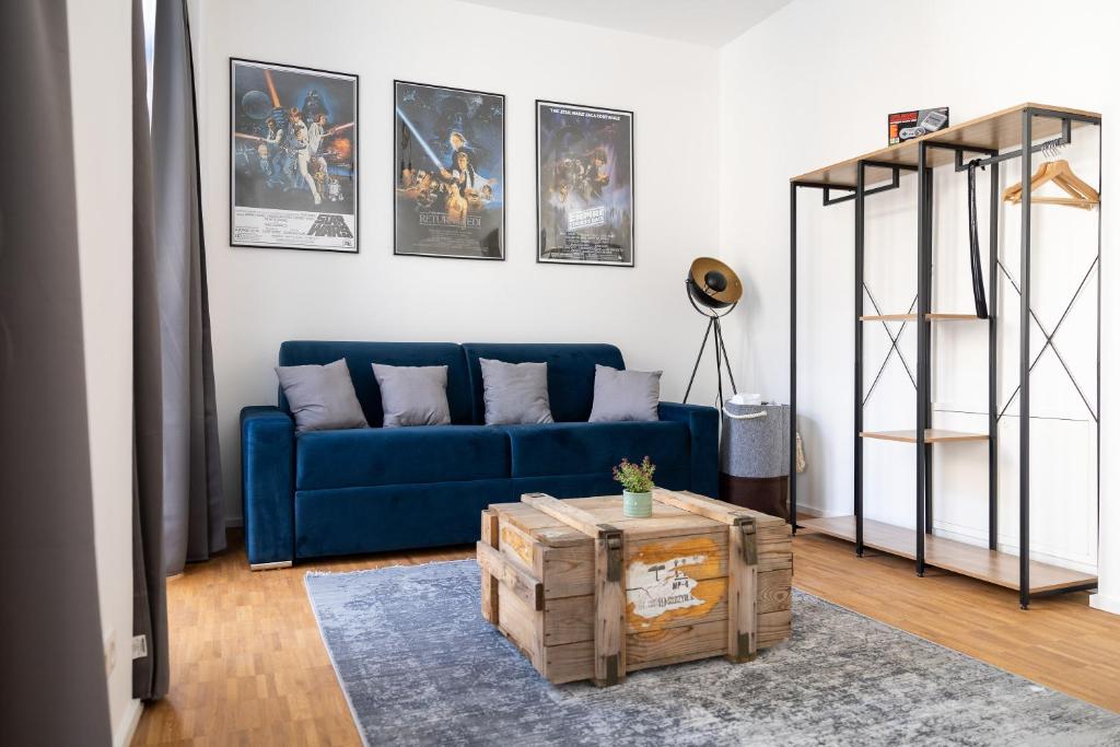 萨勒河畔哈雷Ko-Living - Gaming Suite am Alten Markt - Altstadt - 6P的客厅配有蓝色的沙发和墙上的照片