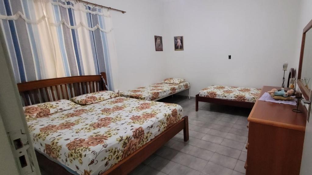 阿帕雷西达Aconchego Sagrada Face的一间卧室配有两张床、一个梳妆台和一张桌子