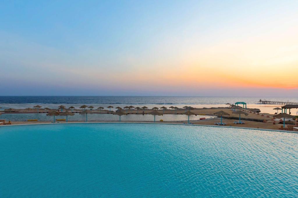 库塞尔库塞尔丽笙度假酒店的日落时分海滩旁的游泳池