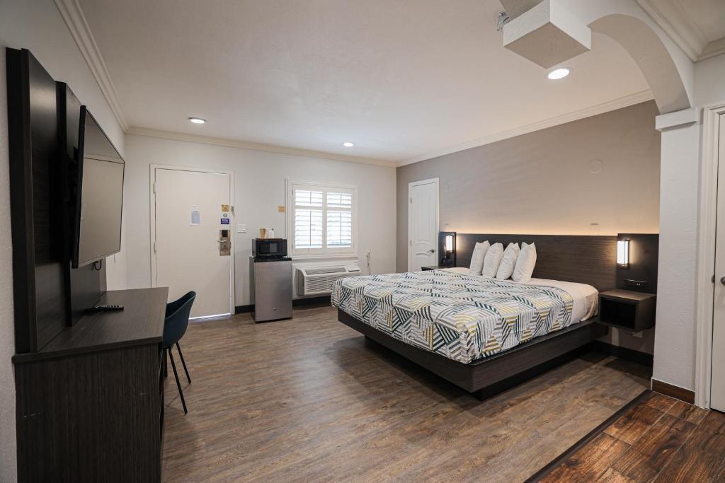 塔斯廷Motel 6 Tustin, CA Orange County的配有一张床和一台平面电视的酒店客房