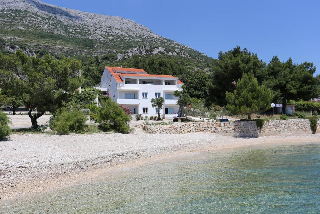 库希斯特Apartments by the sea Kuciste - Perna, Peljesac - 4545的海滩上树木和水的房子