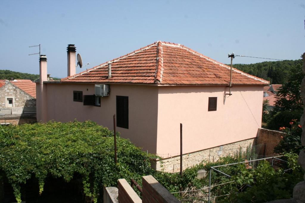韦伯斯卡Rooms by the sea Vrboska (Hvar) - 4600的白色房子,有红色屋顶