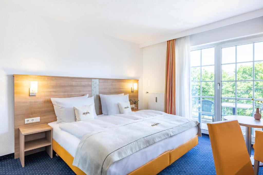 杜塞尔多夫acora Düsseldorf Living the City的酒店客房设有一张大床和一张桌子。