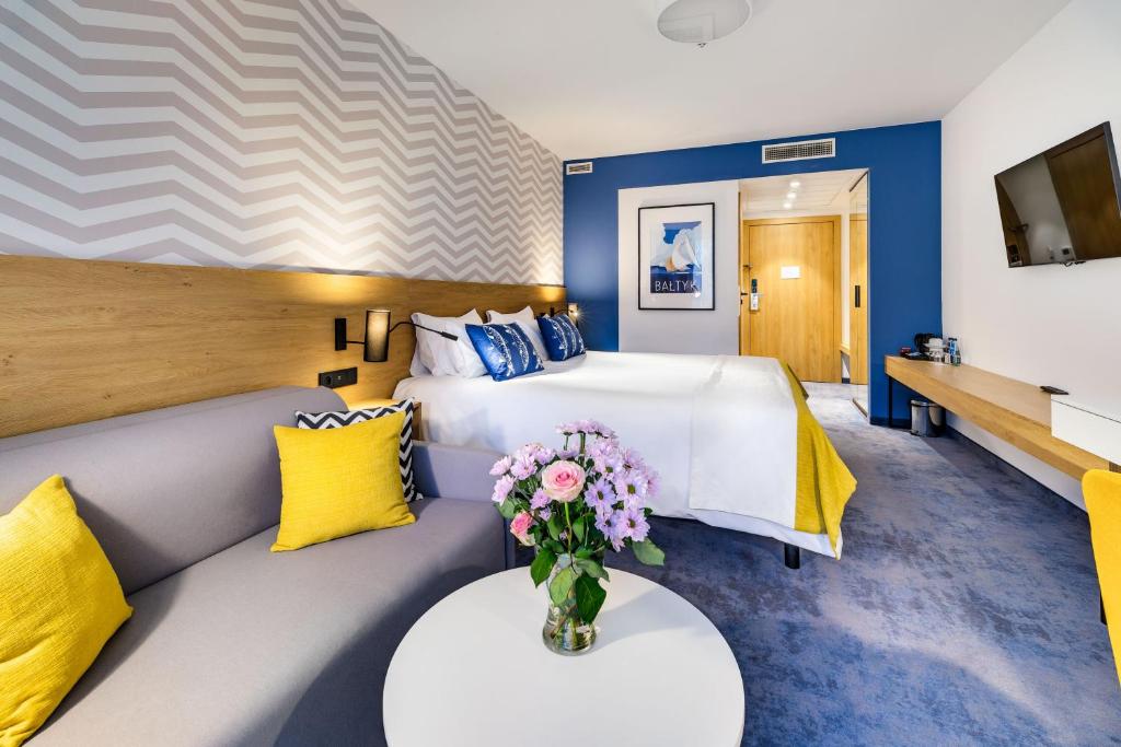 拉塔朱拉塔贝斯特韦斯特酒店的酒店客房,设有一张床和一张花瓶沙发