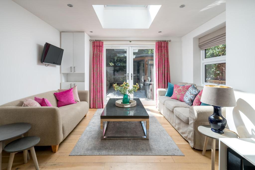 伦敦JOIVY 2-bed flat with garden in Battersea的客厅配有沙发和桌子
