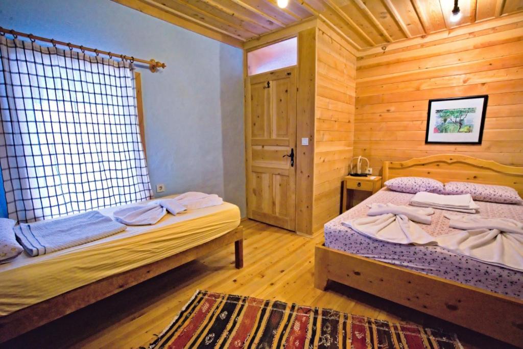 Kaleucagız卡莱民宿的小木屋内一间卧室,配有两张床