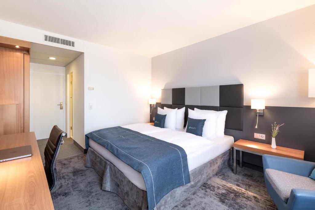 吕塞尔斯海姆鲁塞尔舍姆精选酒店的酒店客房配有一张带蓝色毯子的大床