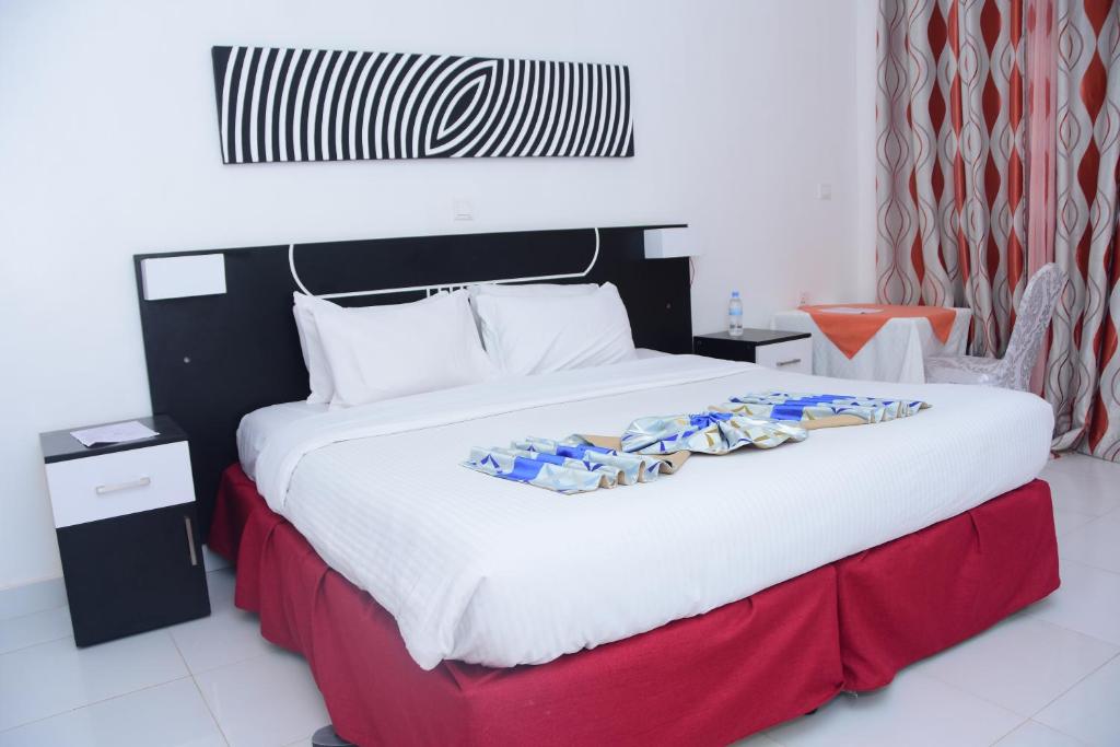 KayonzaSilent Hill Hotel Kayonza的一间卧室配有一张大床,铺有红白毯子