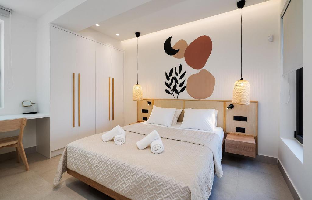 海若克利欧KoNoSo Luxury Apartments的一间卧室配有一张带两条白色毛巾的床