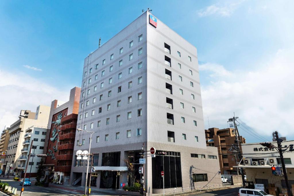 大阪SureStay Plus Hotel by Best Western Shin-Osaka的一条城市街道上高大的白色建筑