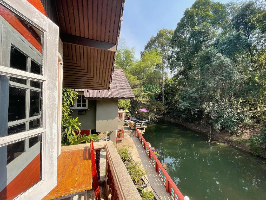 北冲Chomklong Experience的从房子的窗户可欣赏到河流美景