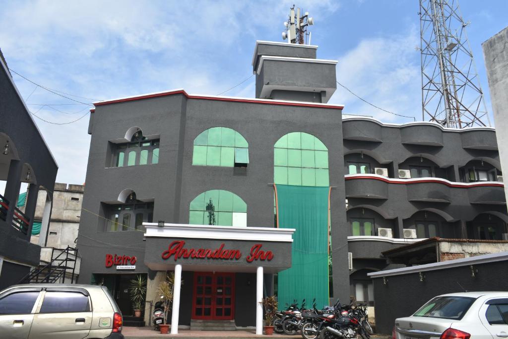 SeonīAnnandam Inn(Hotel Anand)的前面有汽车停放的建筑