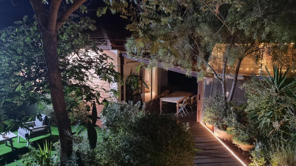阿拉德Olives的一座带花园的房屋,晚上配有桌椅