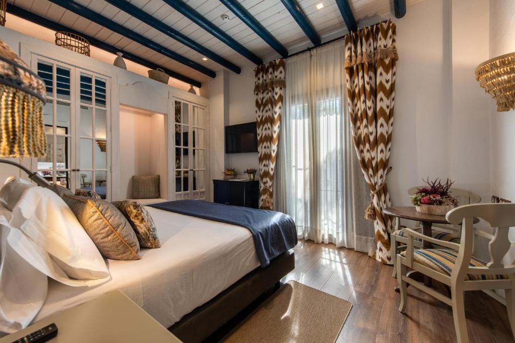 埃尔罗西奥Hotel La Malvasía的卧室配有1张床、1张桌子和1把椅子