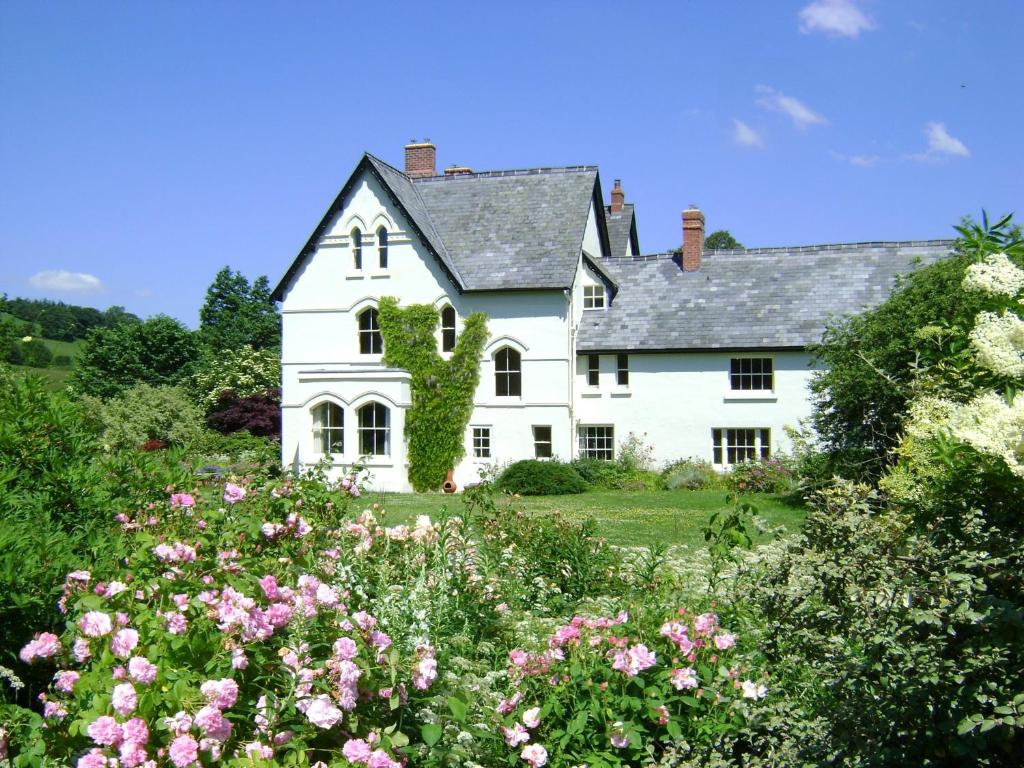 纽敦森林乡村别墅住宿加早餐旅馆的前面有鲜花的白色房子