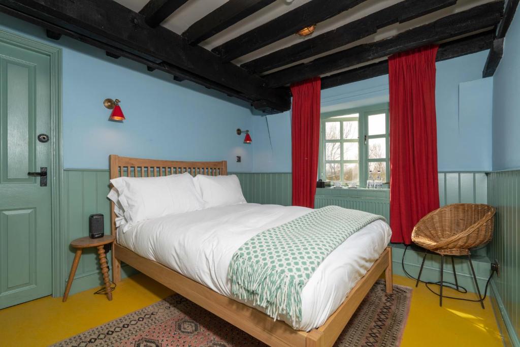 费克纳姆Sculthorpe Mill的一间卧室配有床和红色窗帘